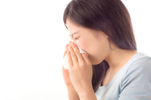Frau niest wegen Allergie